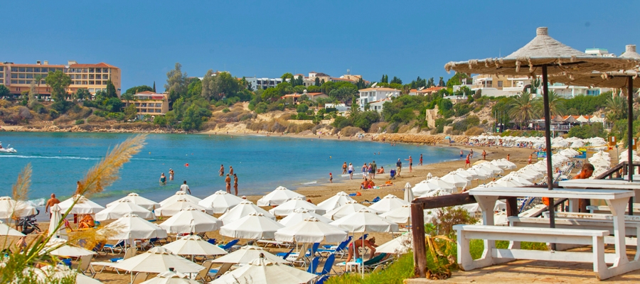 A beach with umbrellas and people in Cyprus
